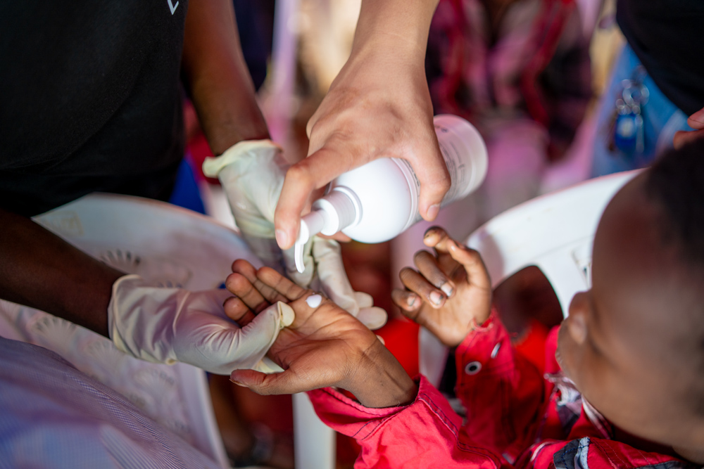 Applying lotion to the hand of a patient